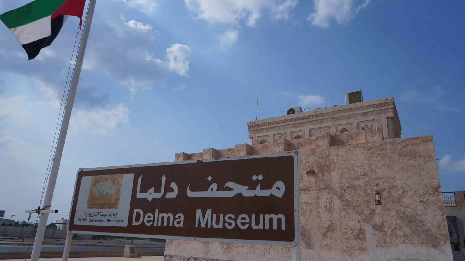 Dalma Island maritime heritage and attractions: flagpole, buildings, street pole, cloudy sky