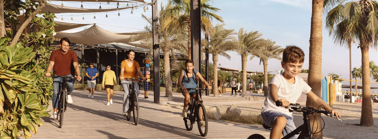 Family biking on Sir Bani Yas Island amidst nature and sky clouds
