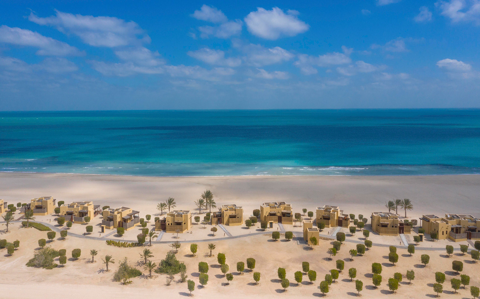 Sir Bani Yas Island Maritime Destinations and Wildlife Sky with clouds, buildings, trees, sand, water