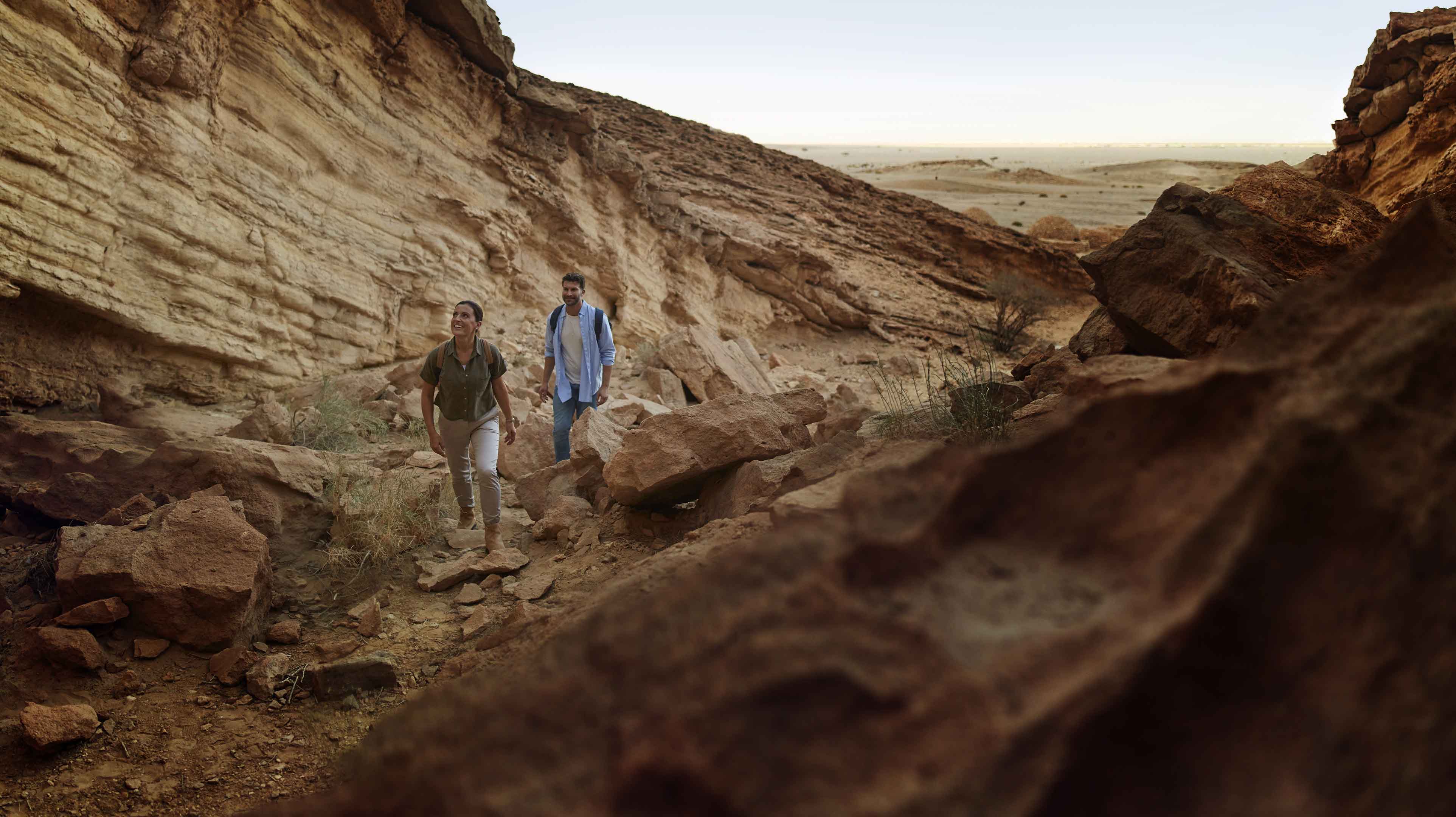 Couple hiking through rocky trails at Jebel Hafit Desert Park in Abu Dhabi.