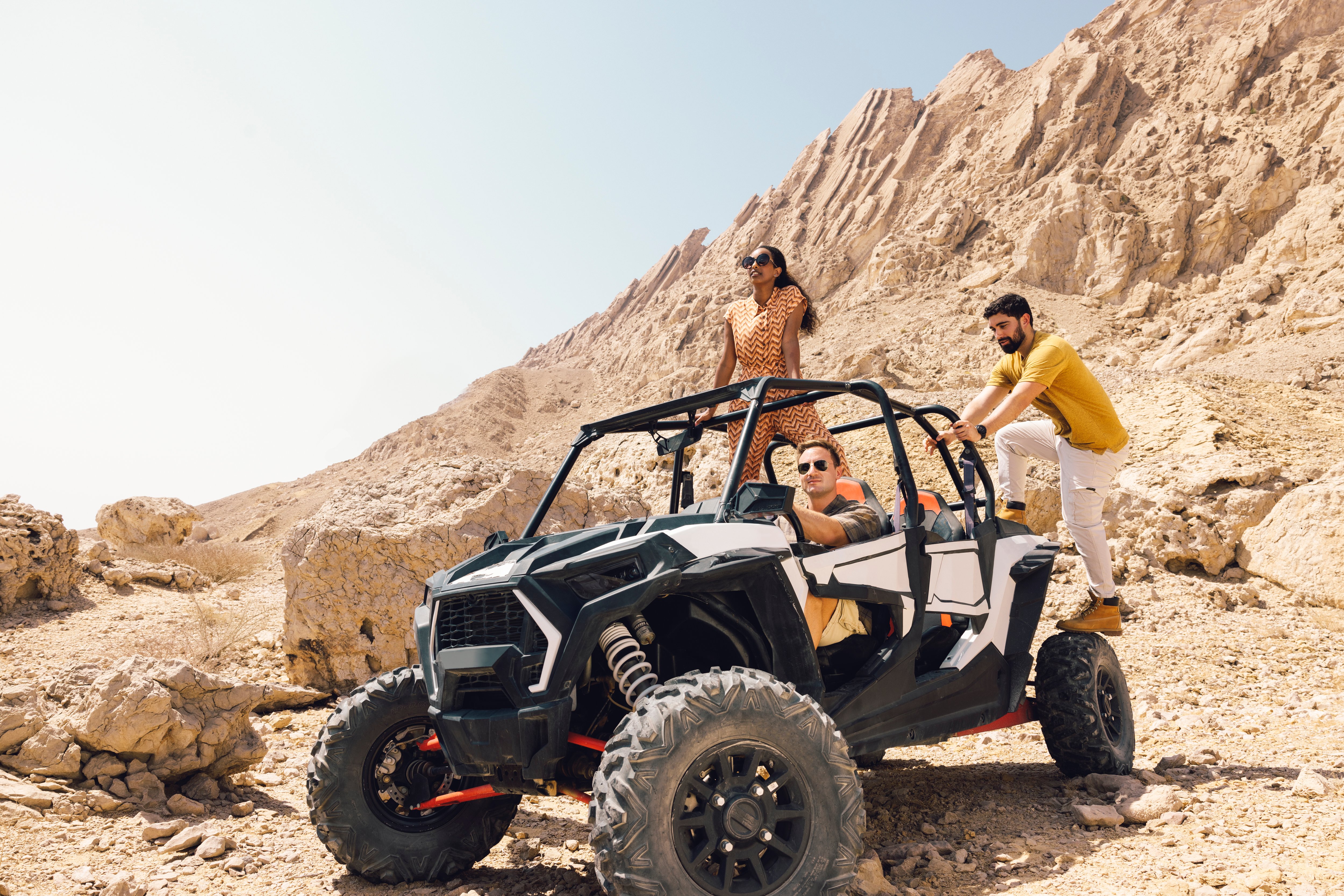 Group enjoying an off-road buggy adventure through rocky terrain at Jebel Hafit Desert Park in Al Ain.