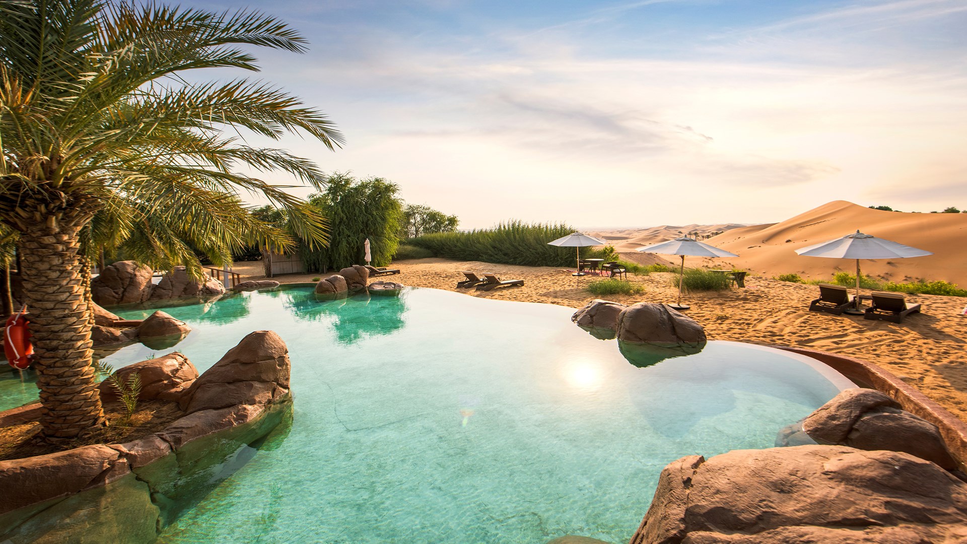 Exotische Oase der Ruhe mit Liegen und Palmen bei Abenddämmerung