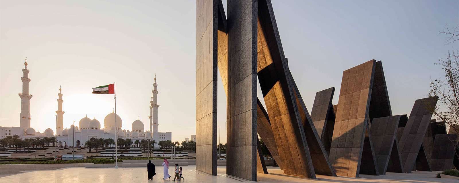 Wahat Al Karama mit beeindruckendem Sonnenuntergang und VAE-Flagge