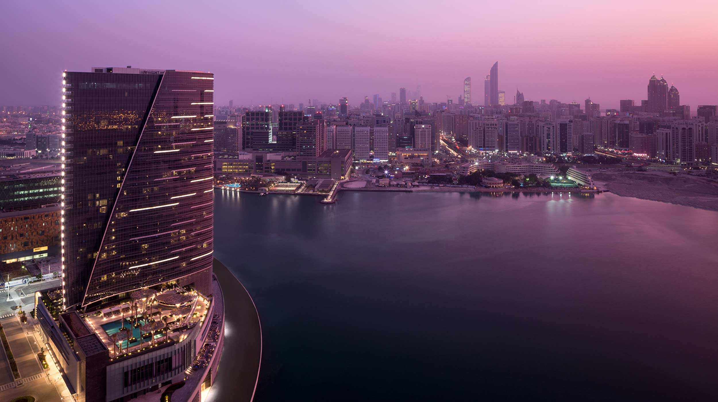  Vue panoramique d'Abu Dhabi depuis l'île d'Al Maryah, illuminée par un coucher de soleil rose.