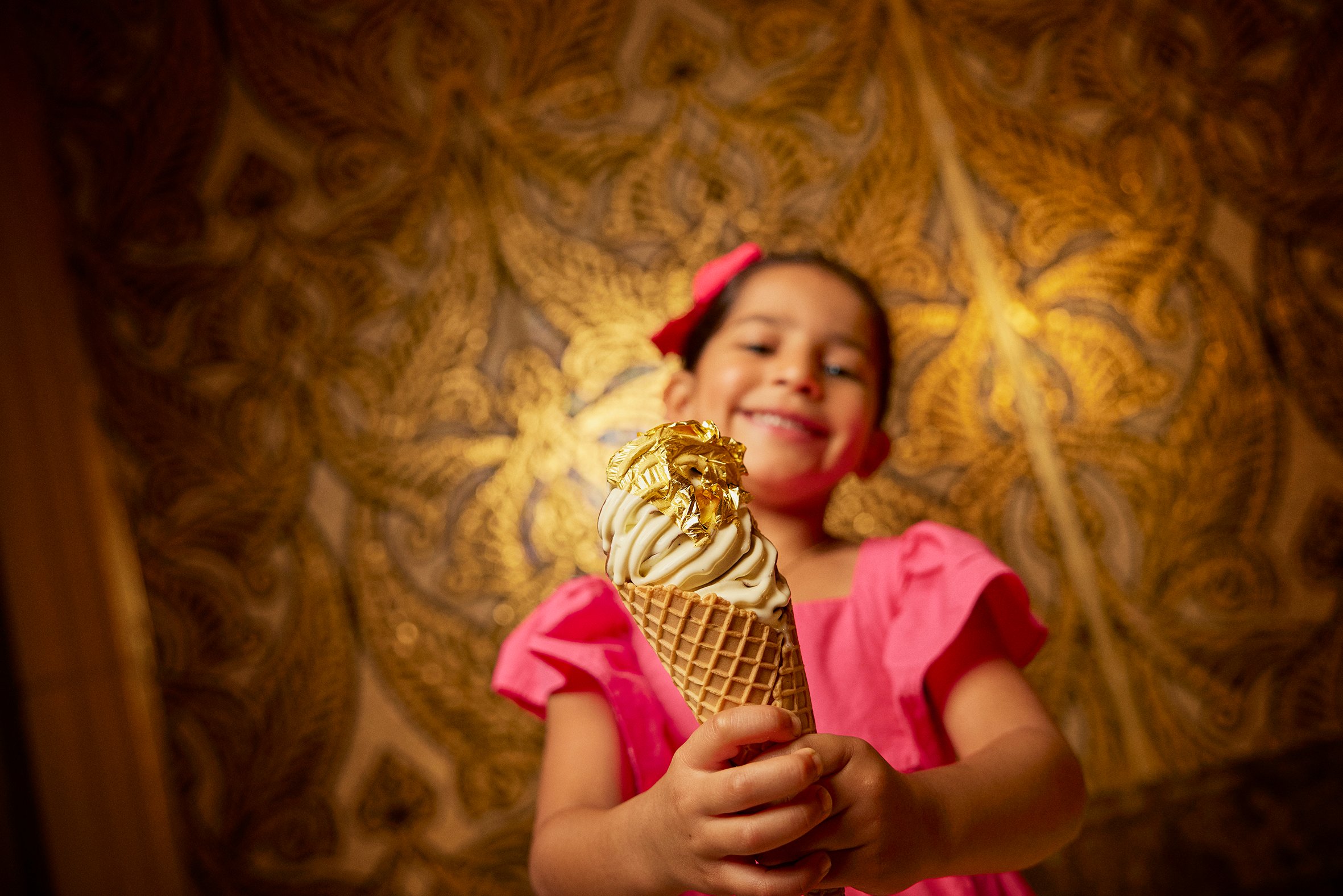 A small girl is holding an ice cream