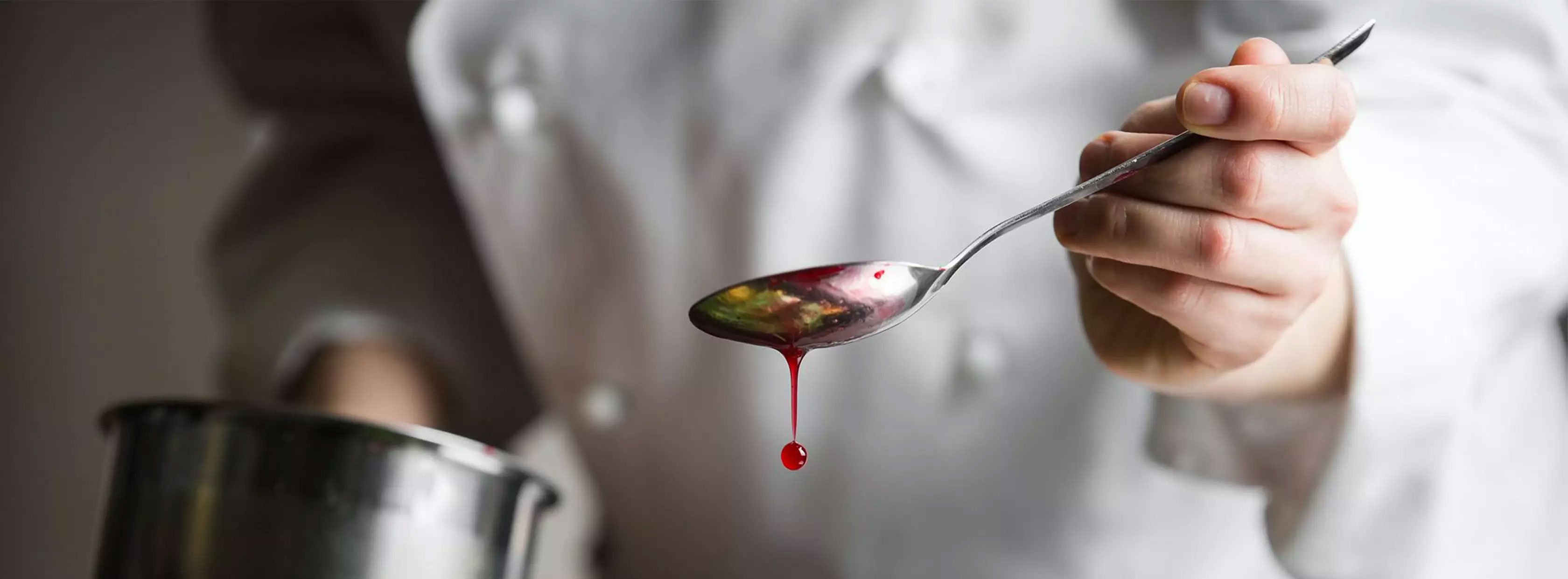 Spoon with sause in a restaurant kitchen