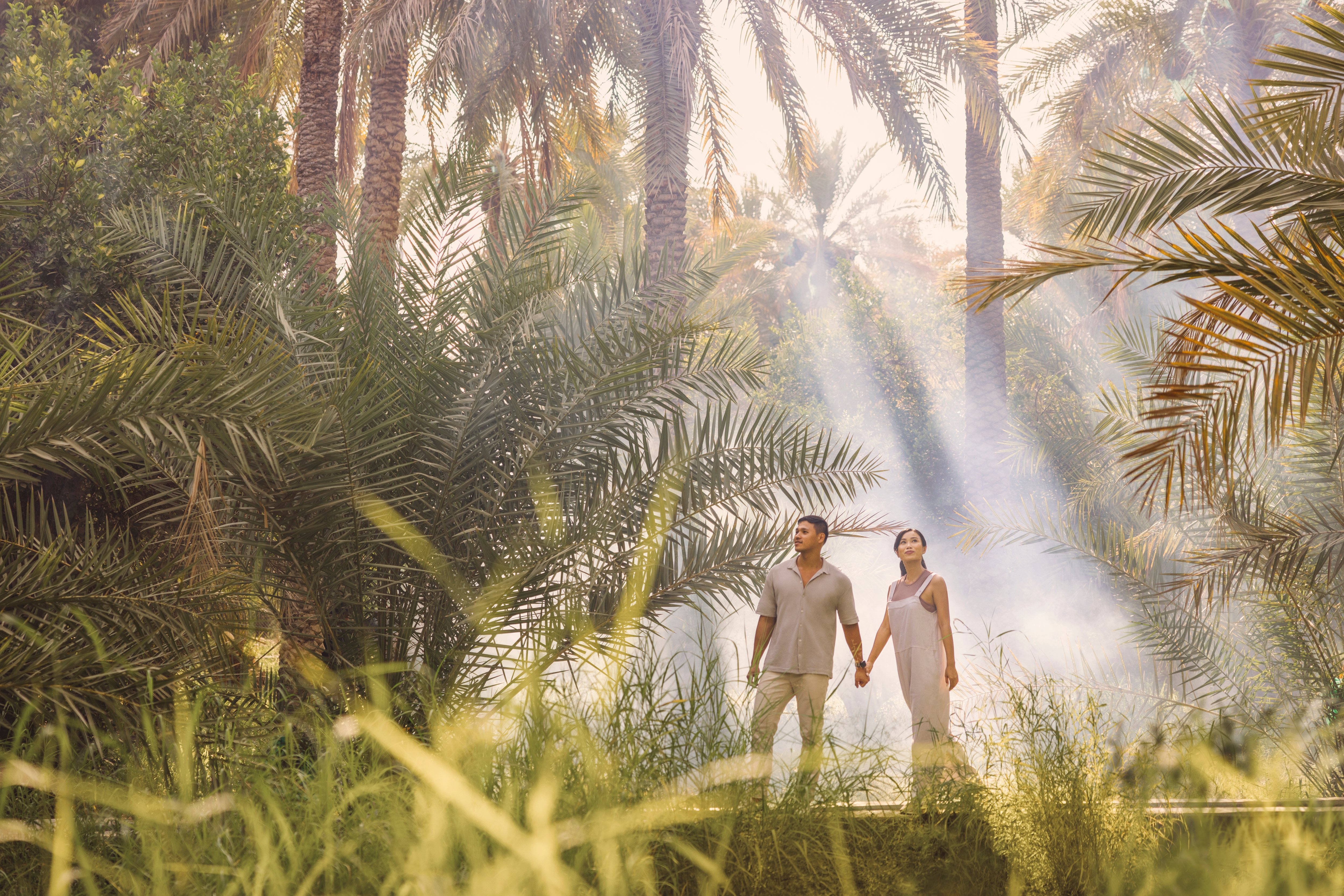 Chinese couple holding hands in the beautiful green outdoors in Al Ain