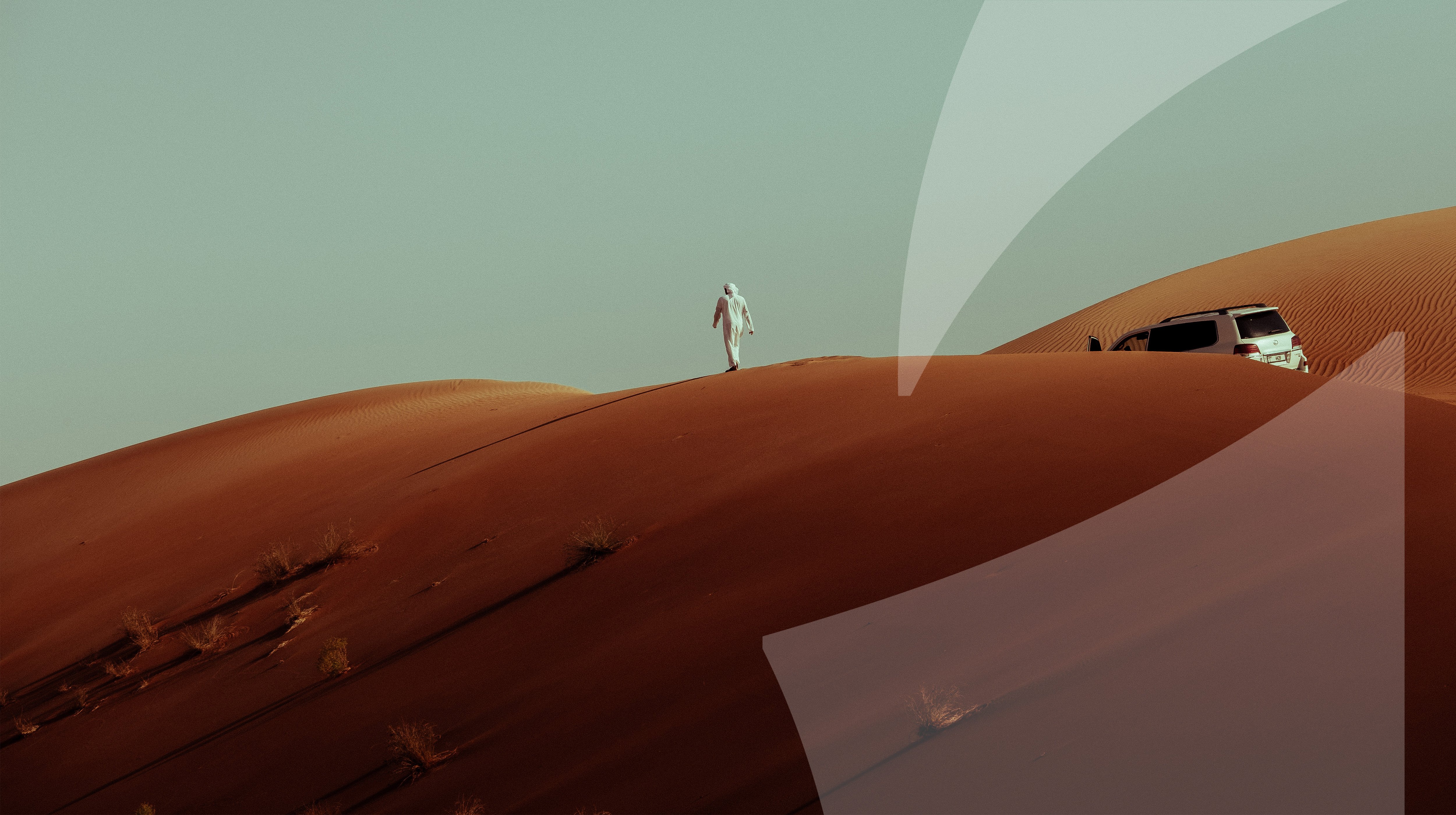 Man walking over Abu Dhabu sand dunes during desert driving