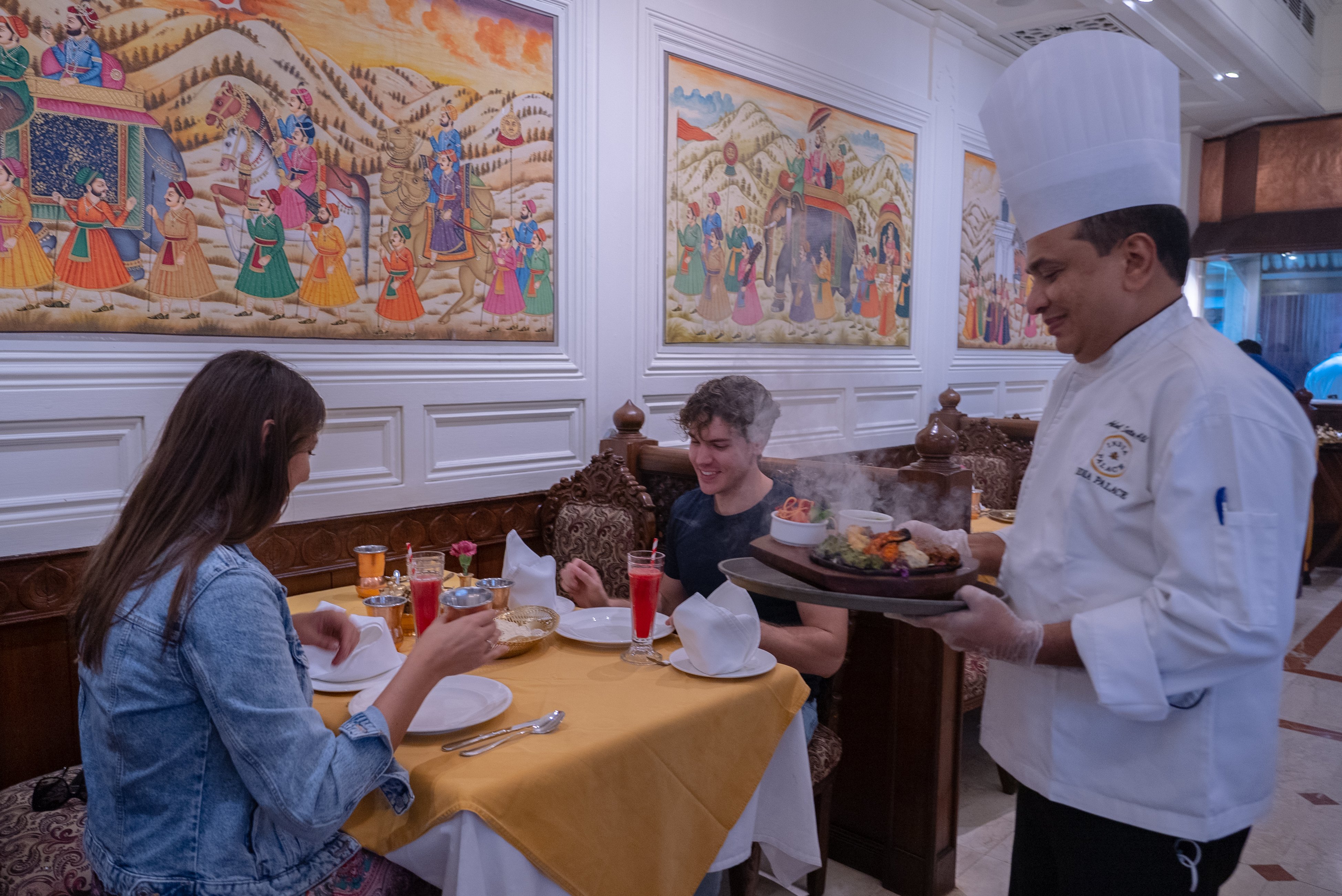 Chef serving two tourists on a free walking tour with delicious tandoori grilled chicken