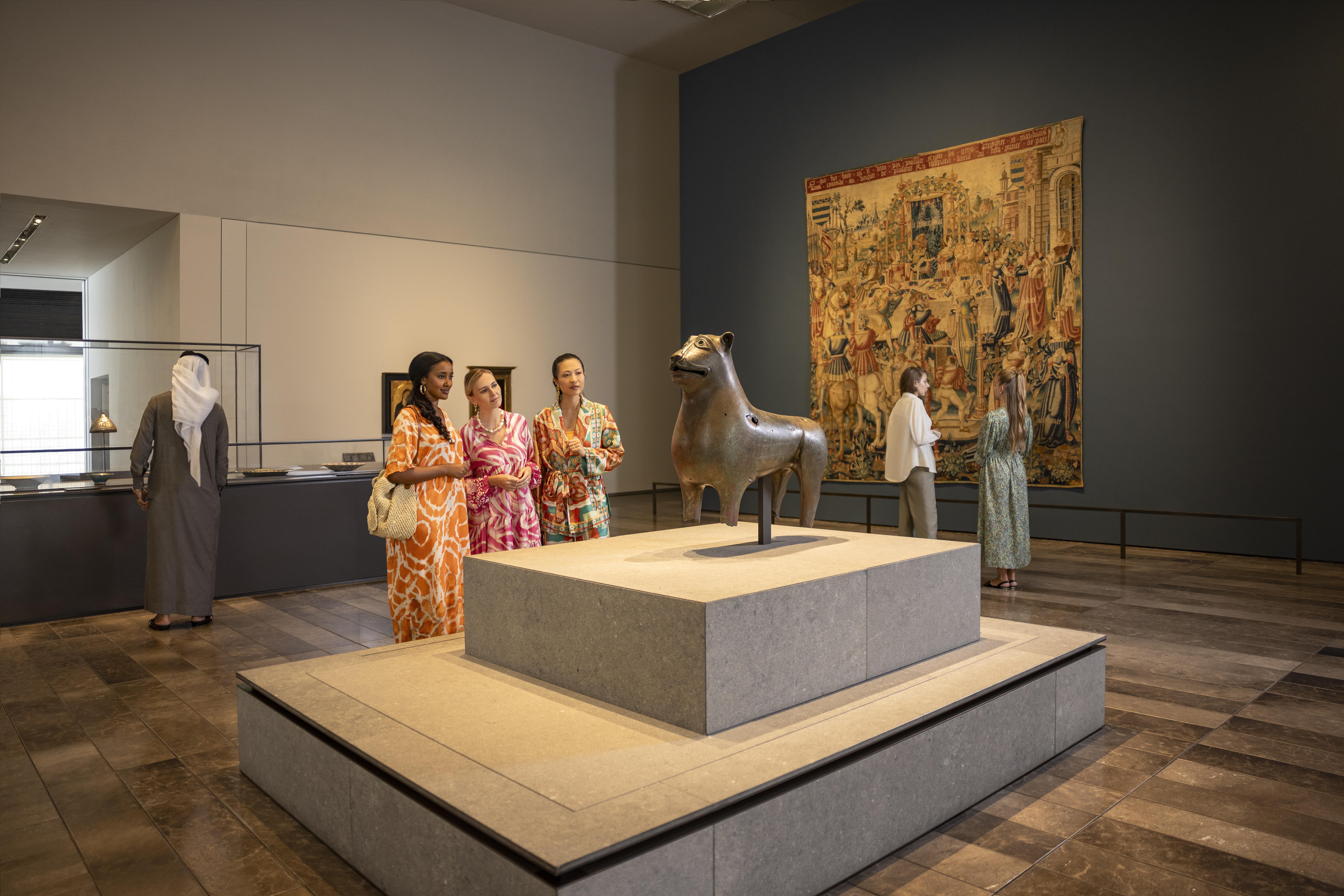 Visitatori che ammirano arte e manufatti al Louvre Abu Dhabi.