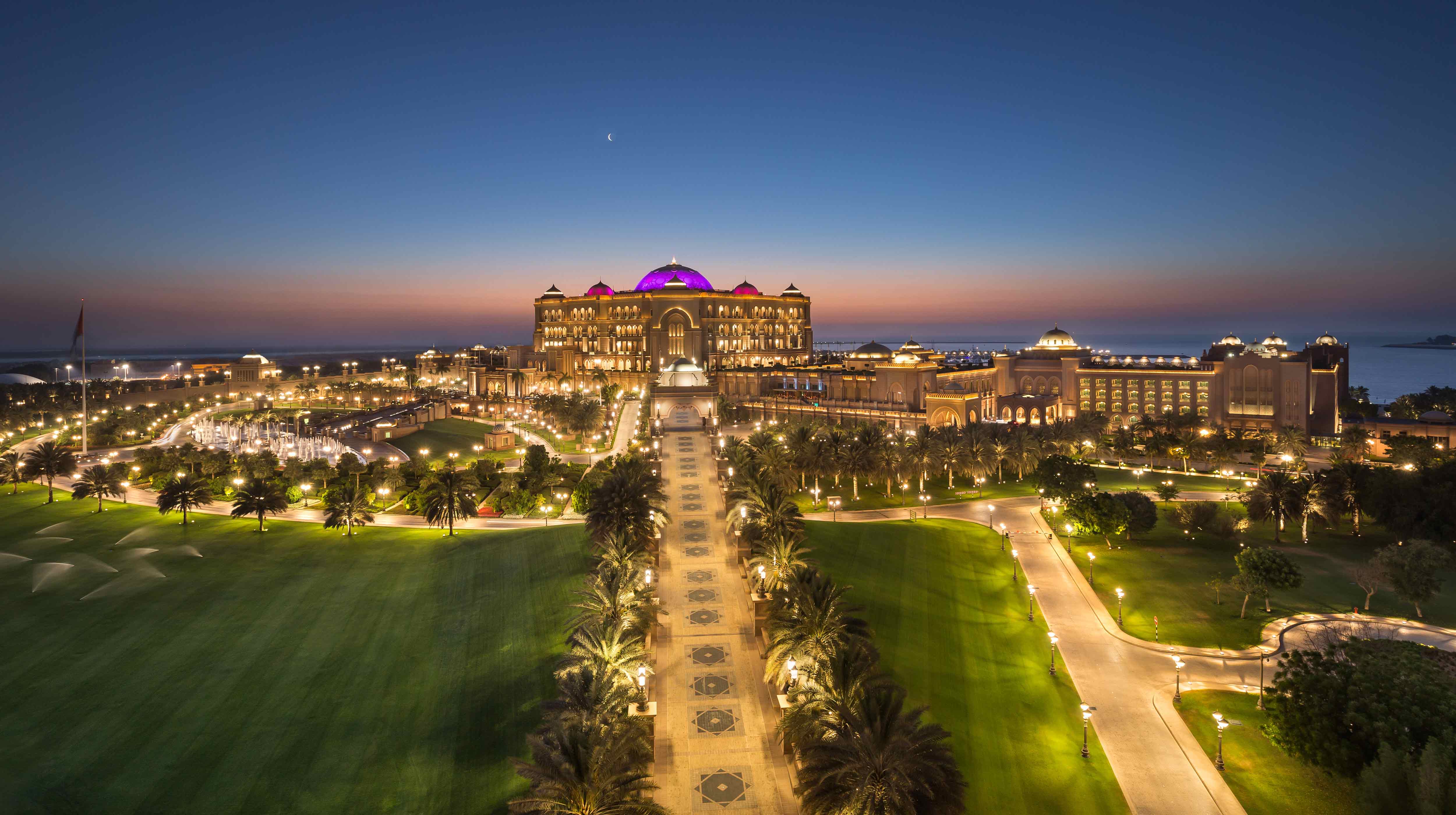  Dans l'éclat du crépuscule, l'Emirates Palace illuminé se dresse majestueusement, reflétant l'élégance d'Abu Dhabi et l'hospitalité des Émirats.