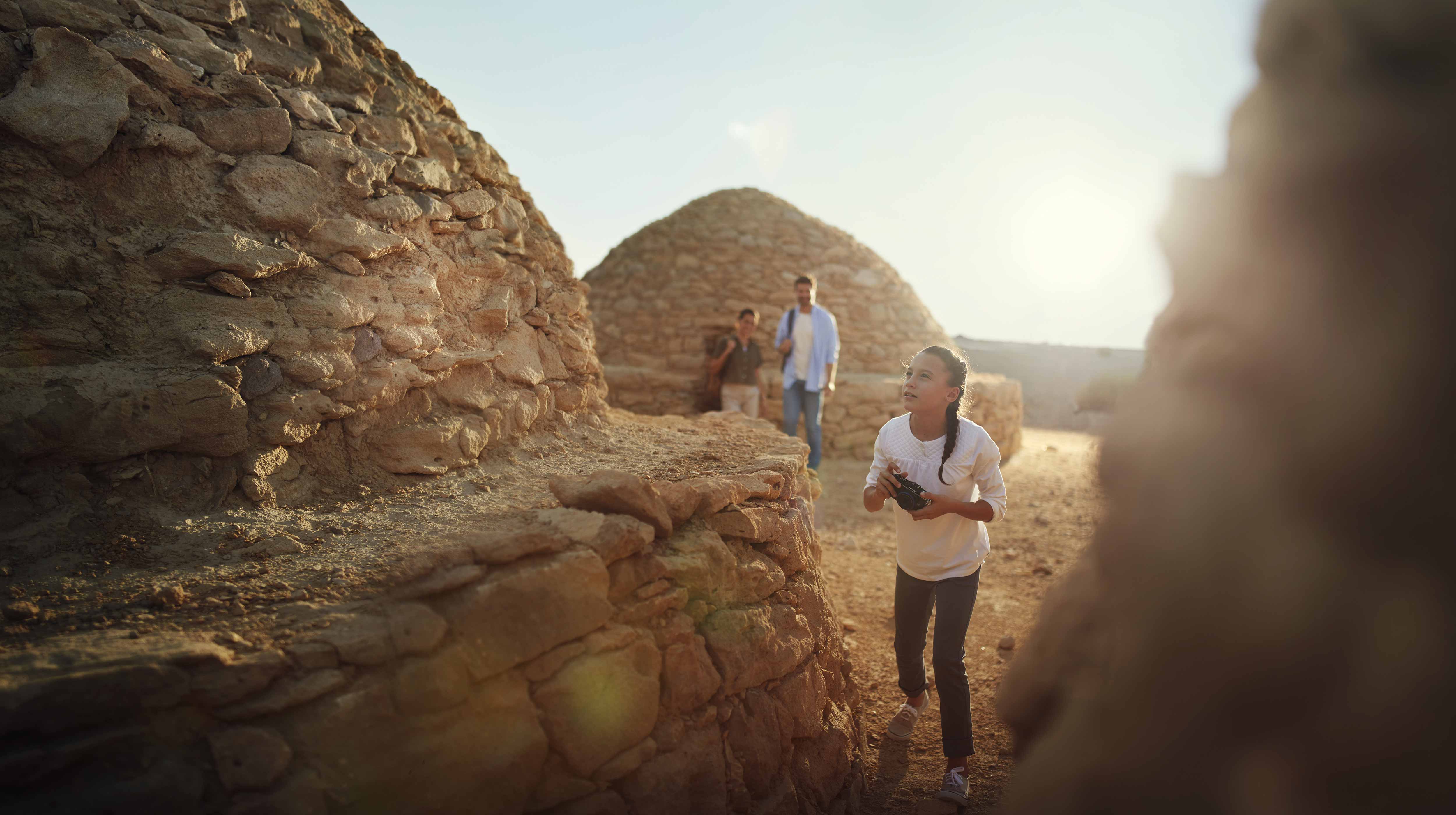 Girl taking photographs of the tombs at Jebel Hafit