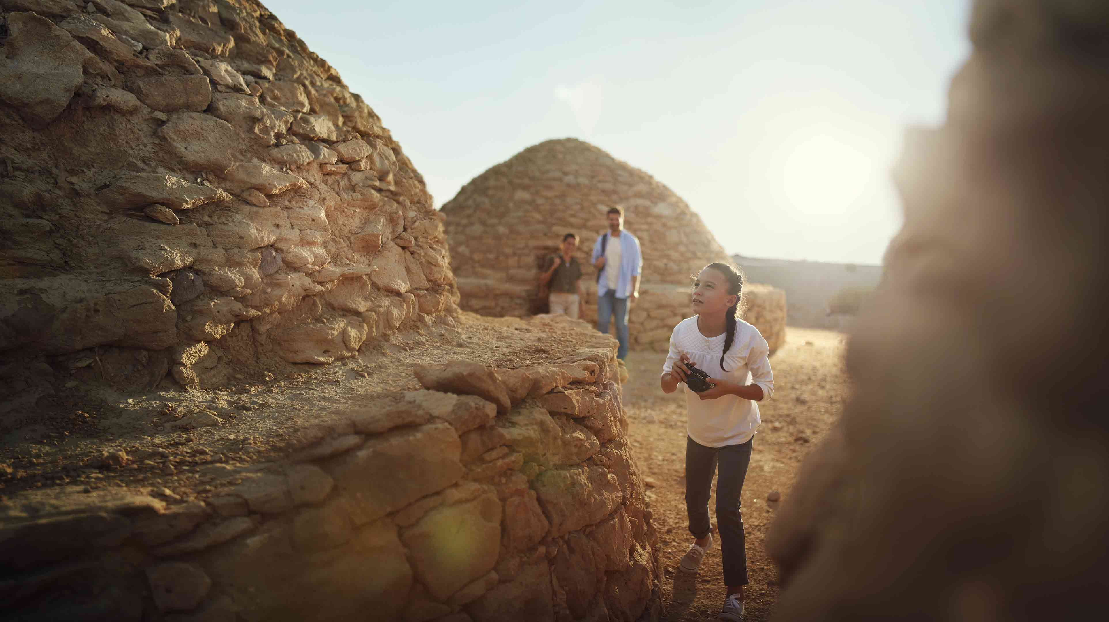 Girl taking photos at the Jebel Hafit tombs, a UNESCO World Heritage site in the UAE