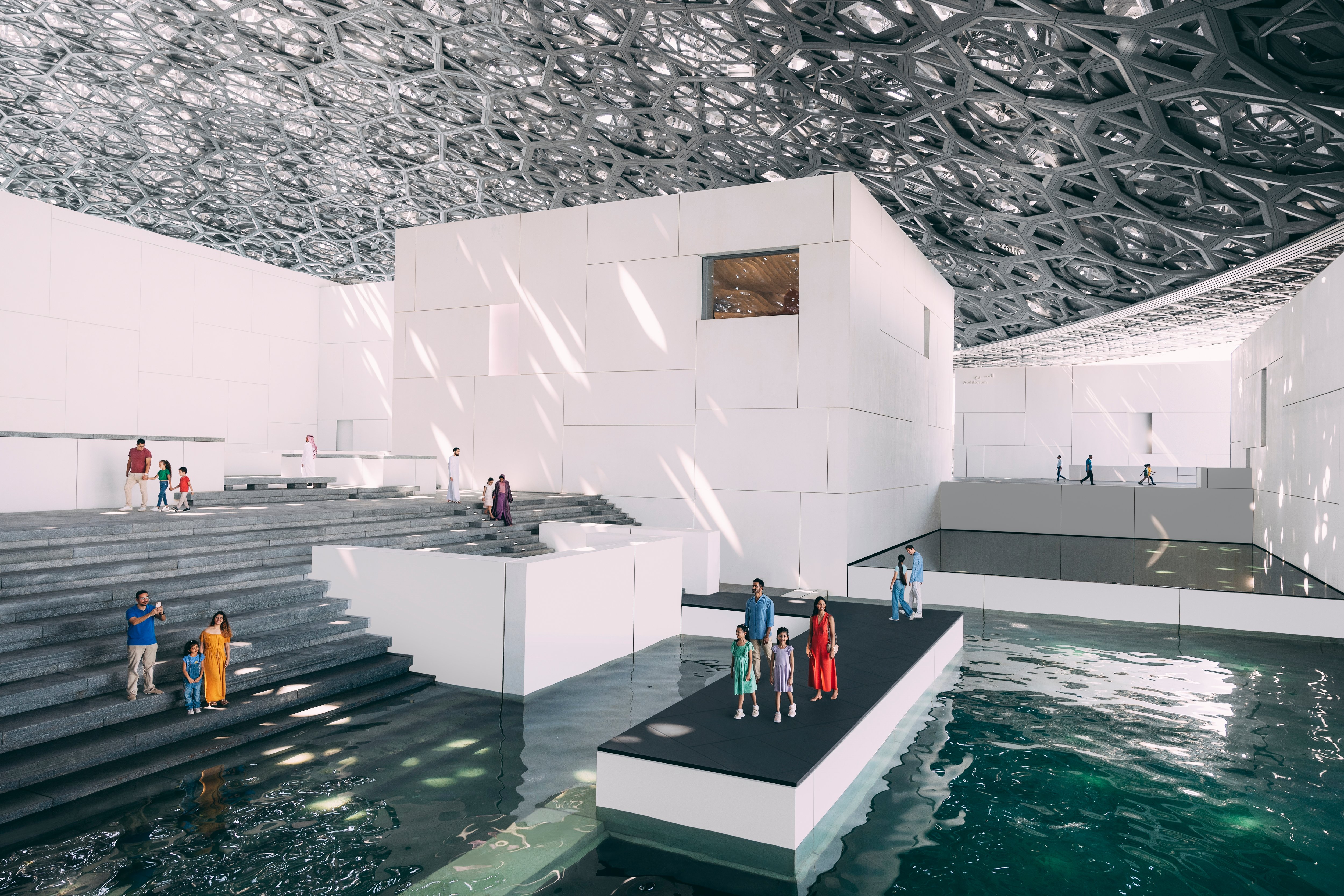 Hommes et femmes d'affaires adultes marchant à l'intérieur dans un Abu Dhabi moderne. Architecture du Louvre et design des sols.