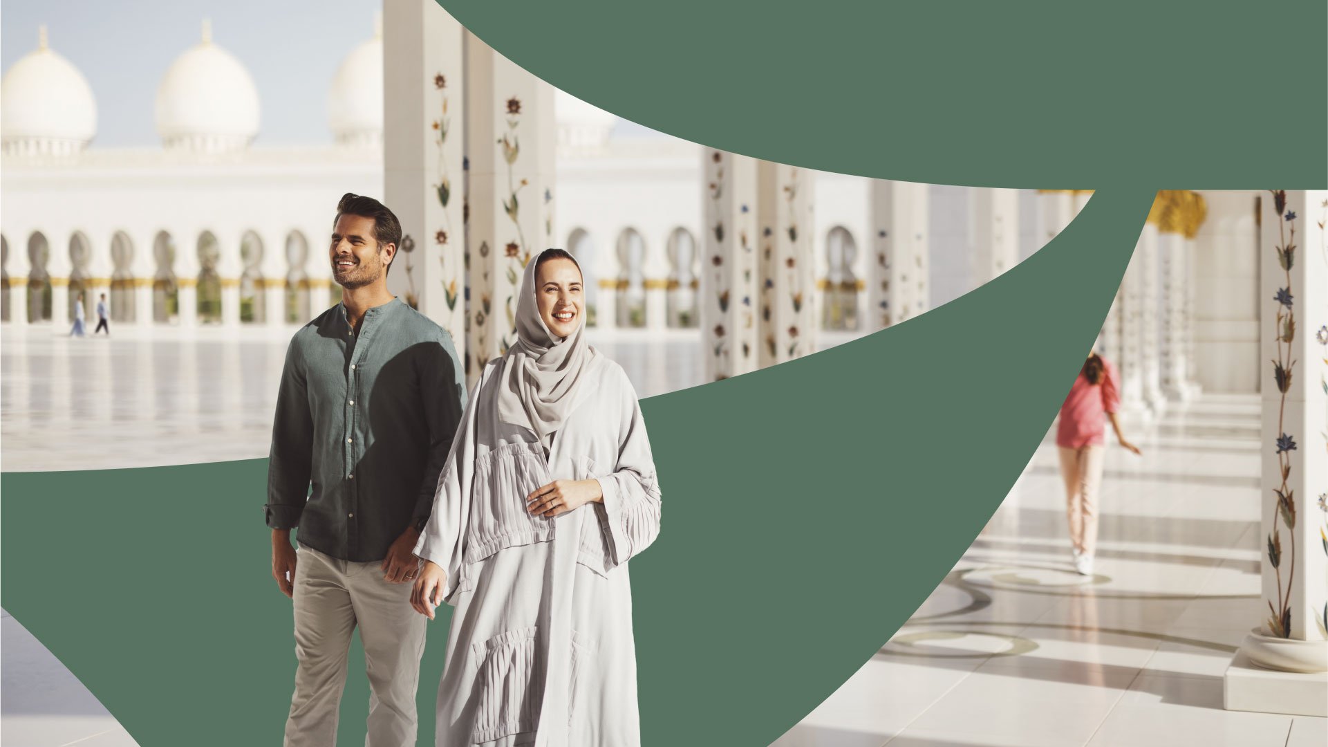 Asian couple smiling and walking outside the Sheikh Zayed Grand Mosque