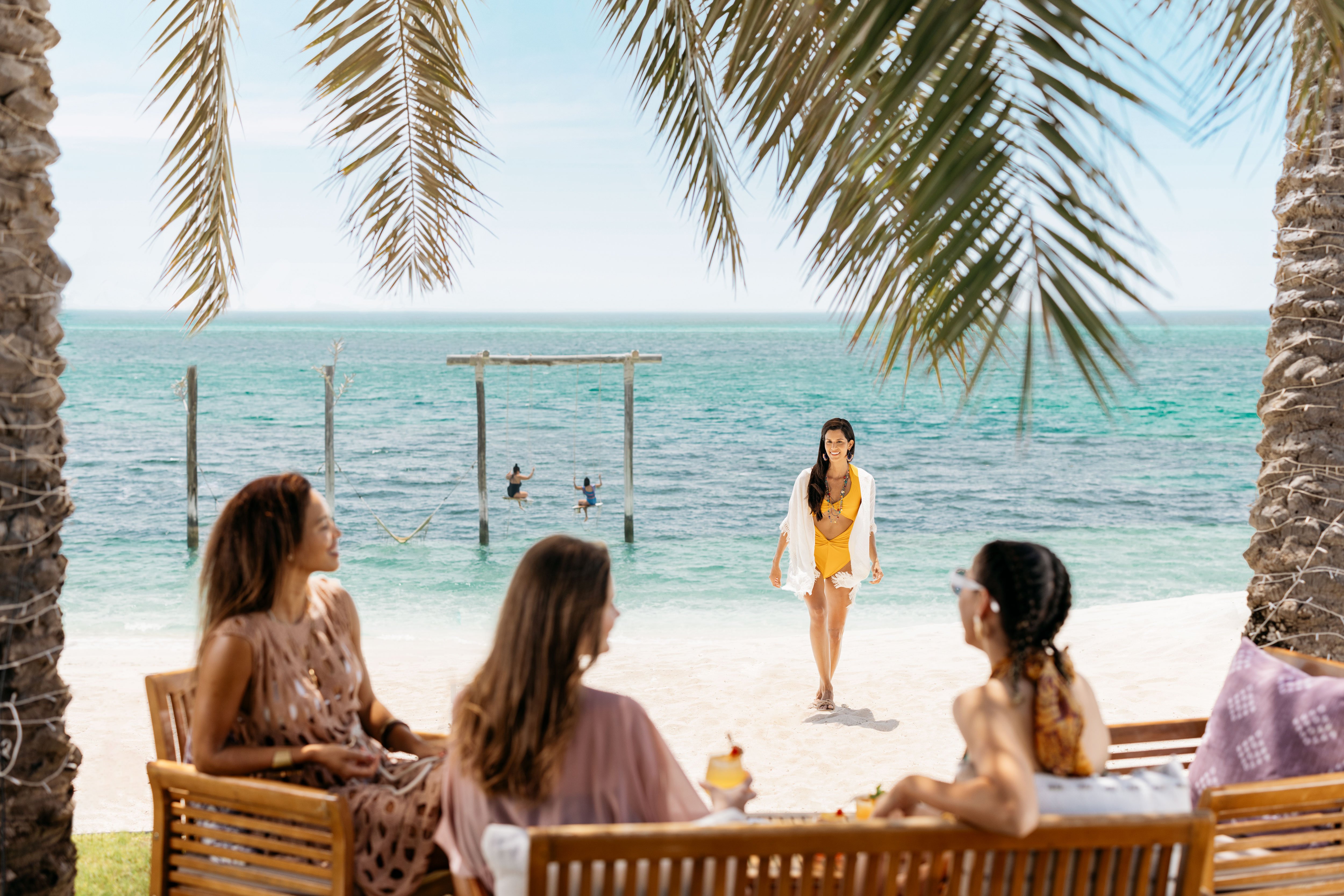 Female friends hanging out together on the beach at Nurai Island