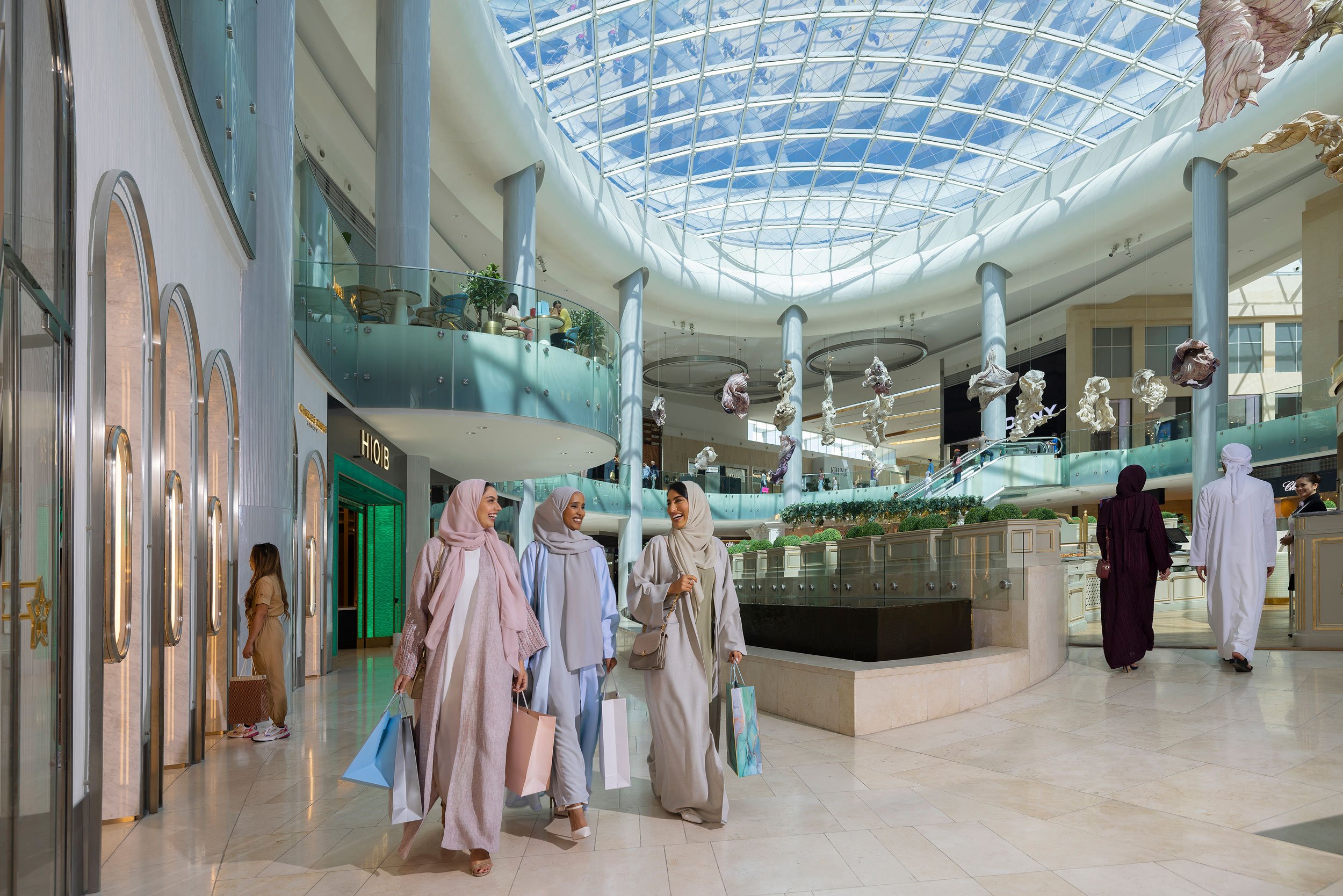 3 ladies shopping and smiling in the mall